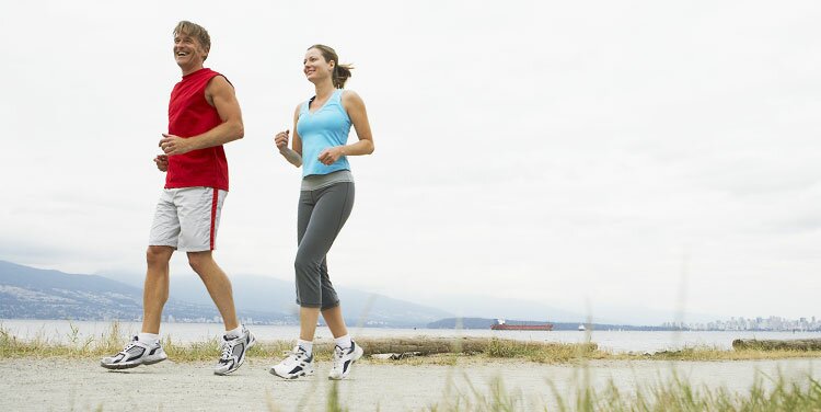 Two people walking together along a tree-lined path